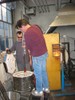 Photo of a glassblower removing the first vase from the annealing oven.