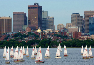 Photograph of boats on Charles River with city of Boston in the background.