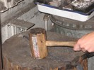 Using a wooden mallet to hammer a metal twist on a tree trunk.