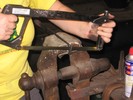 A piece of bar stock is clamped in a vise and the ragged end is sawed off.
