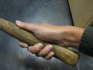 A hammer held with the thumb along the handle.