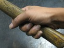 A hammer held with the thumb around the handle.