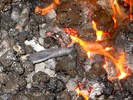 The flattened end of a round bar, heating in the fire.
