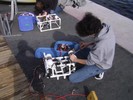 A student attaches the PVC buoy to the robot with a metal hose clamp.