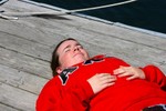 A student lying down on the sunny dock.