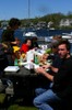 Many people eating lunch at a picnic table.