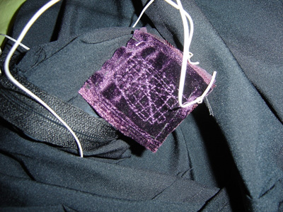 Photo of a small square of fabric with stitching pattern, wired into the the dress.