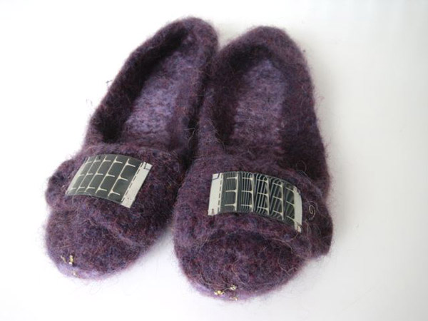 Photo of a pair of felt wool slippers, including small solar panels on the top of each foot.