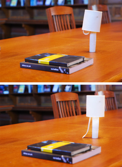 Two photos of the lamp on a table, in off and on configurations.