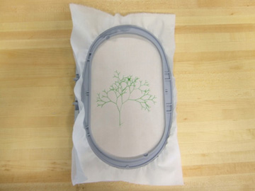 Photo of embroidered fabric in a machine embroidery hoop.