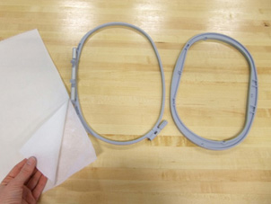 Two photos showing the process of putting fabric and interfacing into a two-part embroidery hoop.