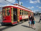 Two female students pose in front of a red streetcar.
