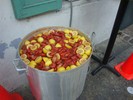 A very large metal container holds a mixture of crawfish and lemons.