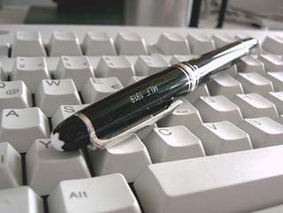 Photograph of pen and computer keyboard.