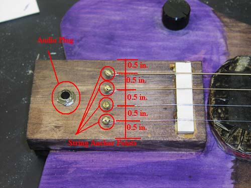 Tailpiece of guitar with string spacing measurements.