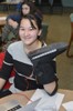 A girl holds a boot with wires attached.