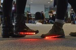 Two women are wearing light up boots with red lights on them.