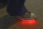 Sneakers with a strip of red lit up LEDs.